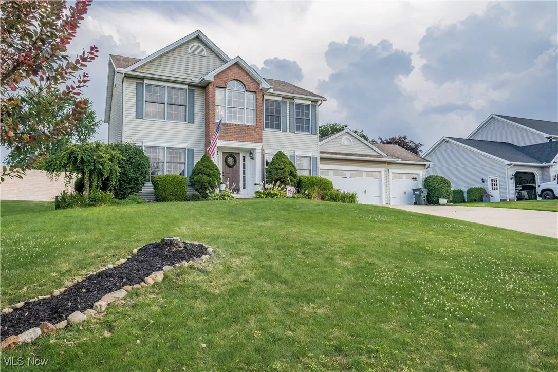 View of front of property with driveway, a garage, and a front lawn