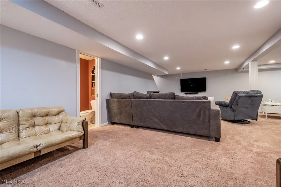 Living area with carpet flooring and recessed lighting