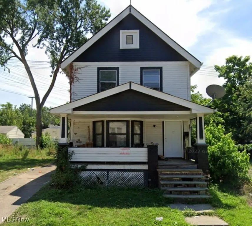 American foursquare style home featuring a front yard and covered porch