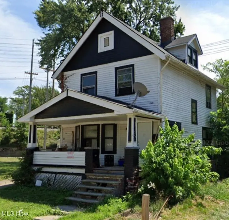 View of front of property with covered porch, a chimney, and a front lawn