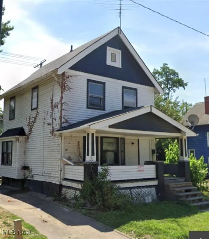 Traditional style home featuring covered porch and a front yard