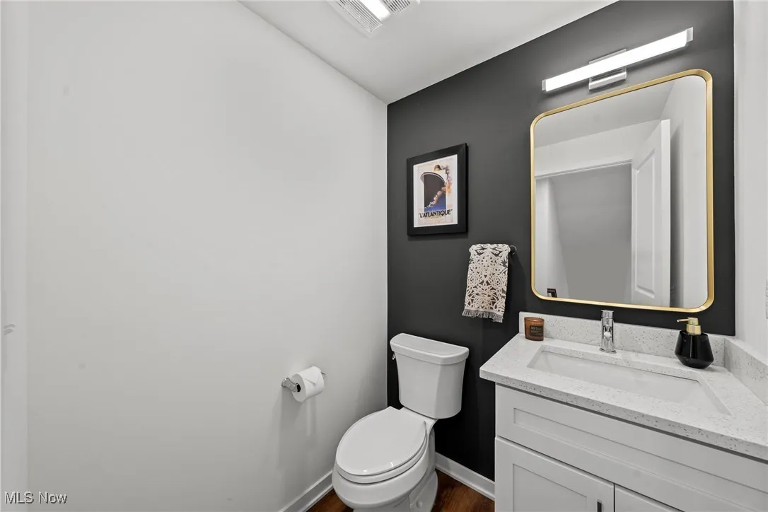 Half bathroom with vanity and wood finished floors