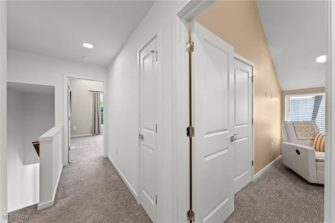 Corridor featuring carpet flooring, recessed lighting, and an upstairs landing