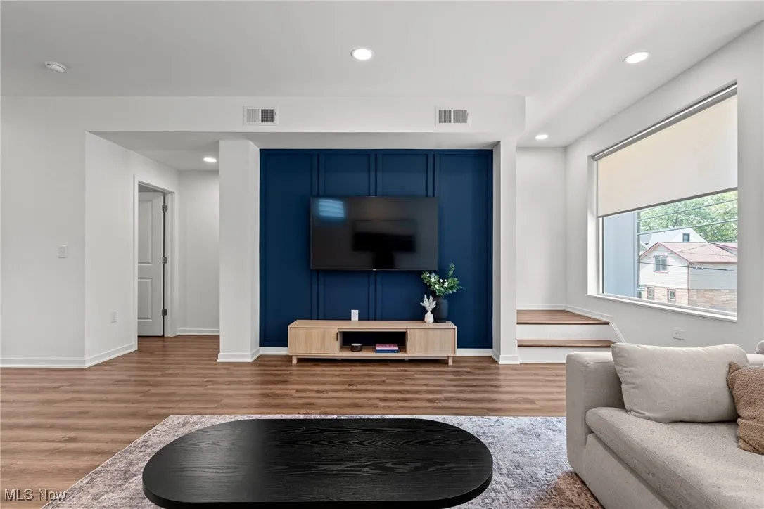 Living area featuring wood finished floors and recessed lighting