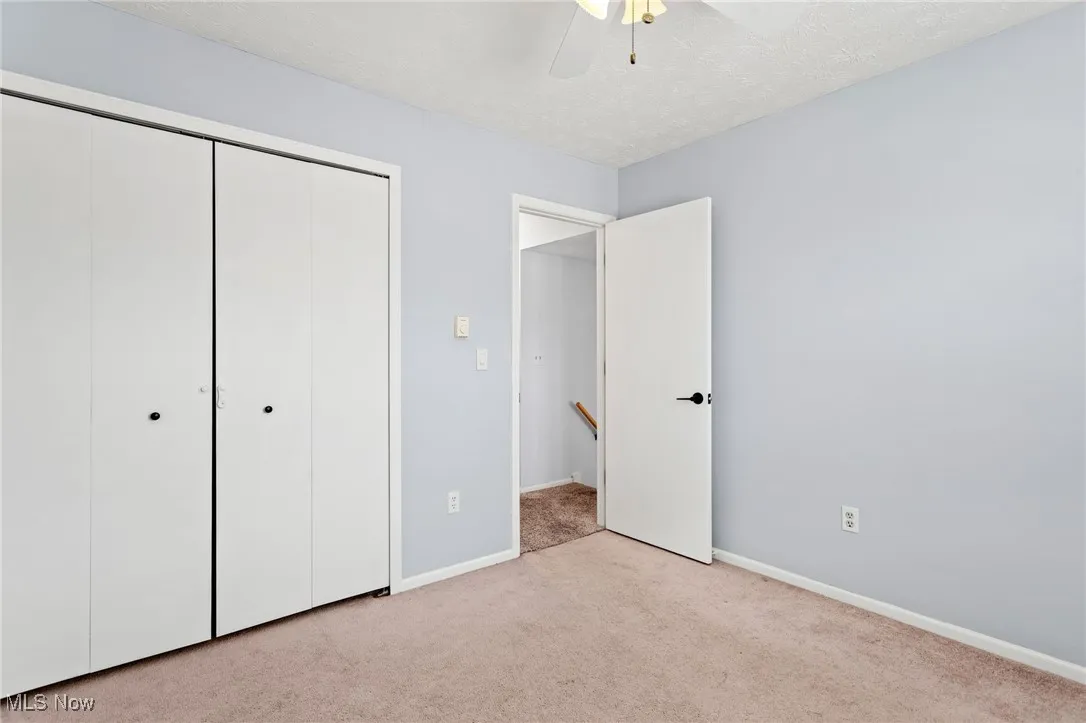 Unfurnished bedroom with carpet floors, a closet, and ceiling fan