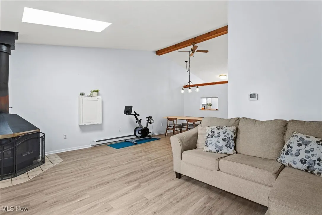 Living area featuring a wood stove, light wood finished floors, and baseboard heating