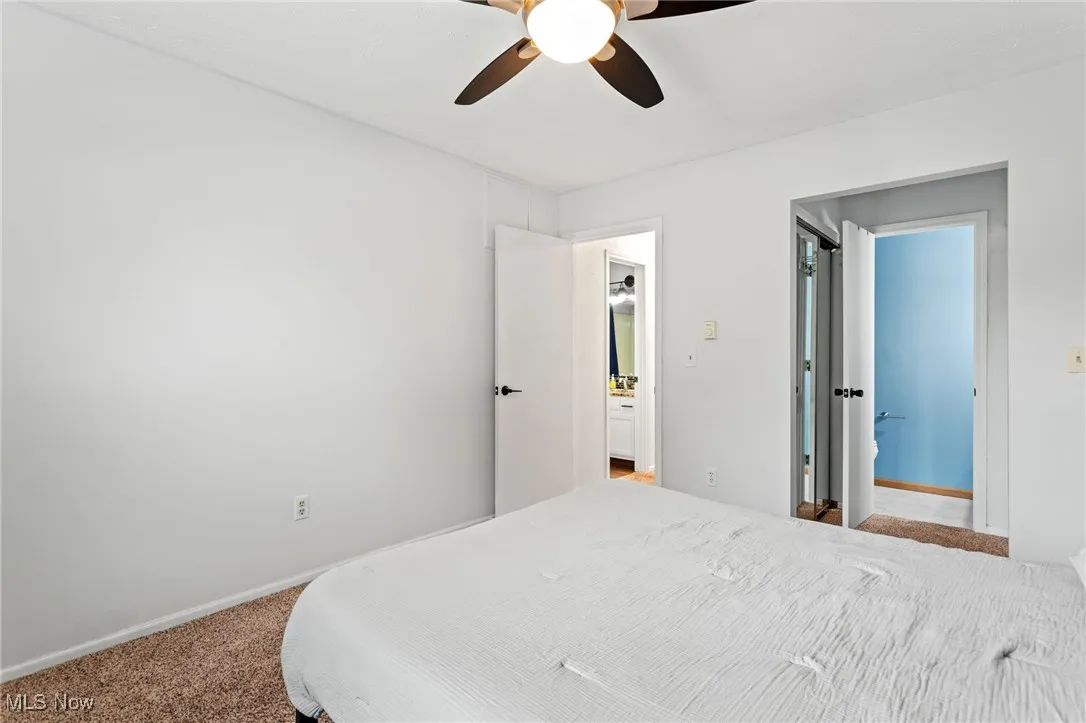 Carpeted bedroom with baseboards and a ceiling fan
