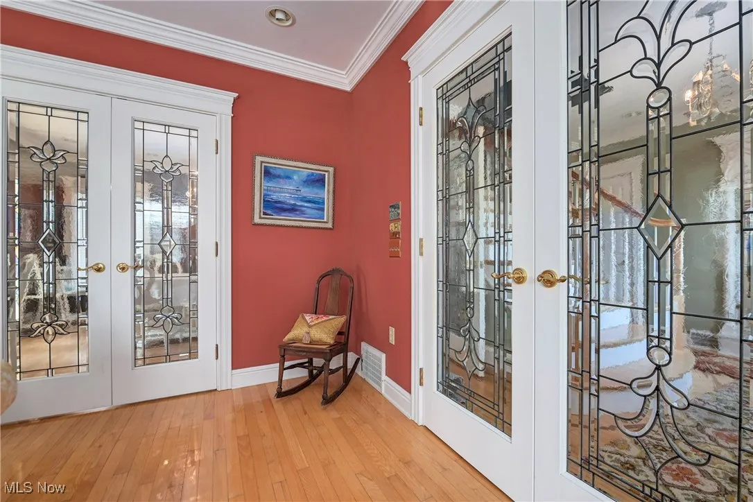 Entryway with french doors, hardwood / wood-style floors, and crown molding