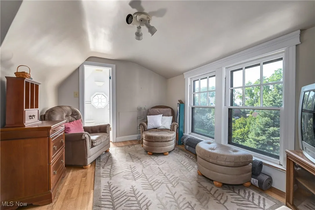 Sitting room with light wood finished floors and lofted ceiling