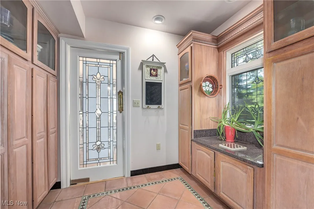 Entrance foyer featuring light tile patterned floors and inlaid floor details