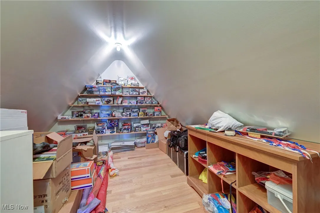 Playroom with wood finished floors and vaulted ceiling