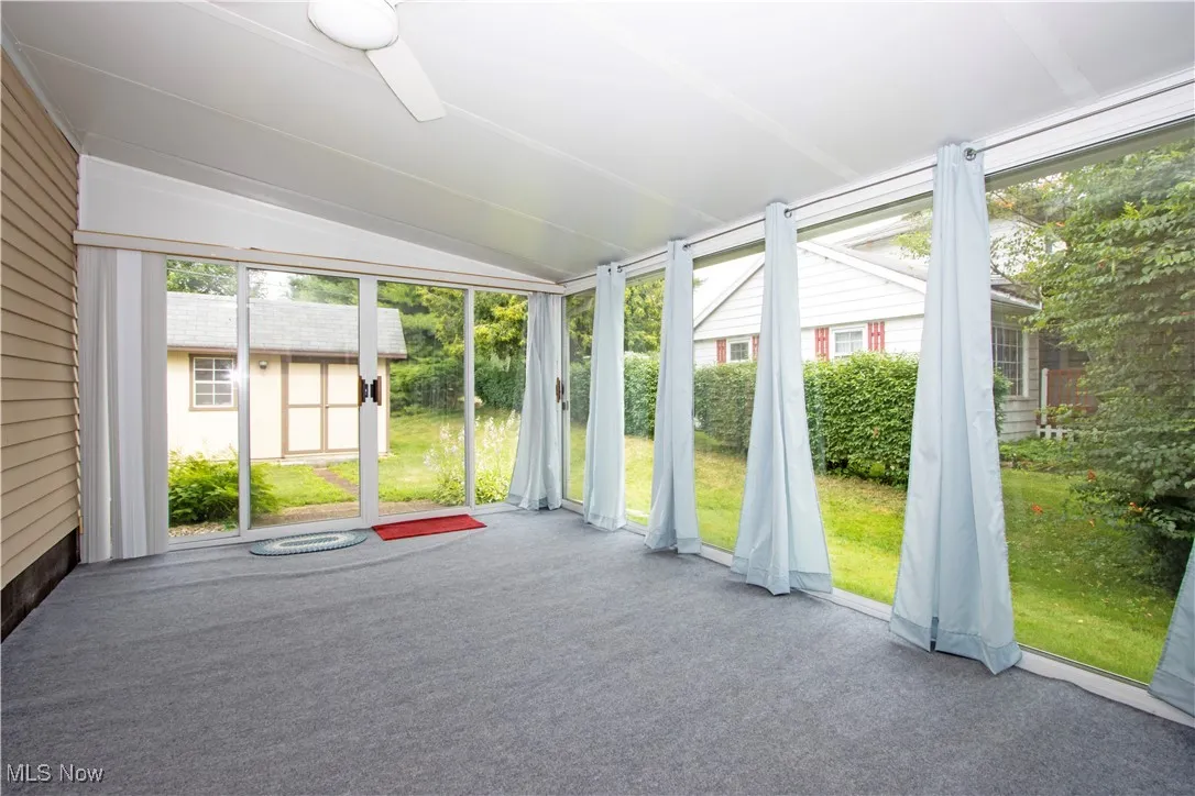 Unfurnished sunroom with plenty of natural light and vaulted ceiling