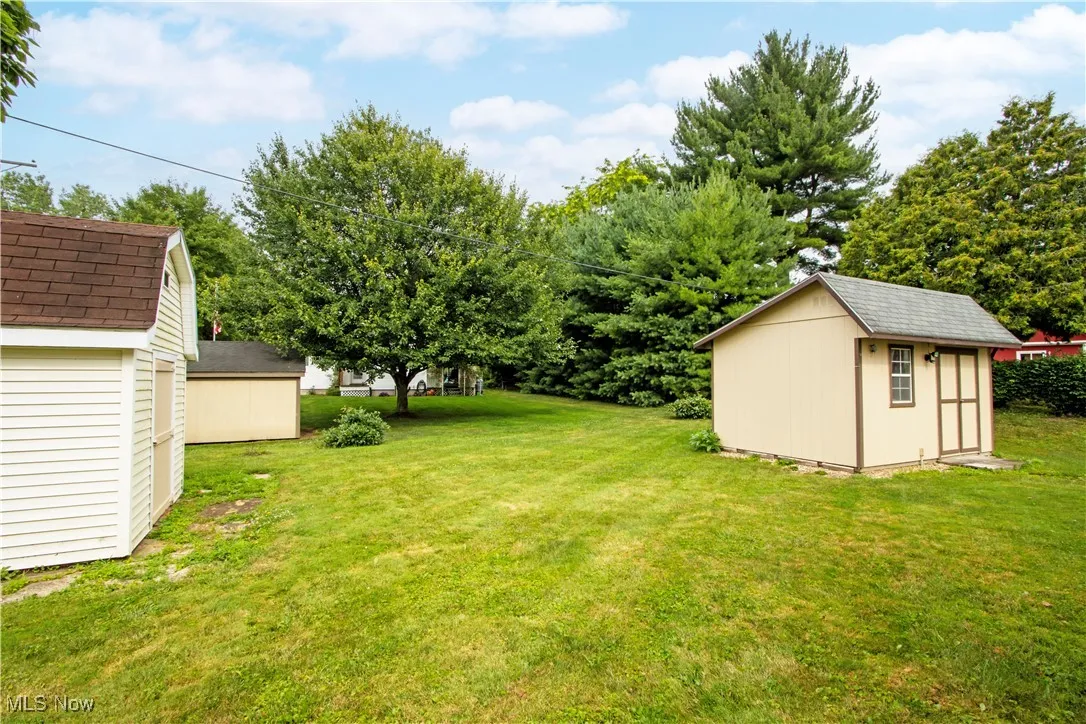 View of green lawn featuring a storage shed