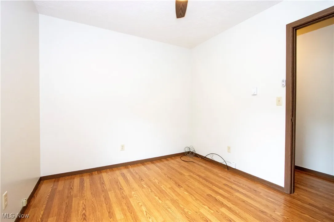 Unfurnished room with wood finished floors and ceiling fan