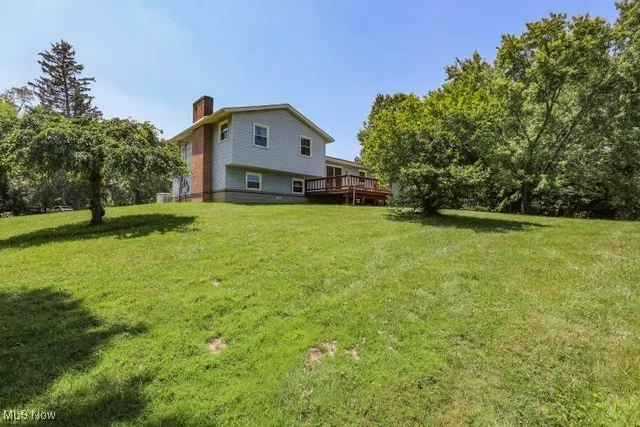 View of grassy yard with a deck
