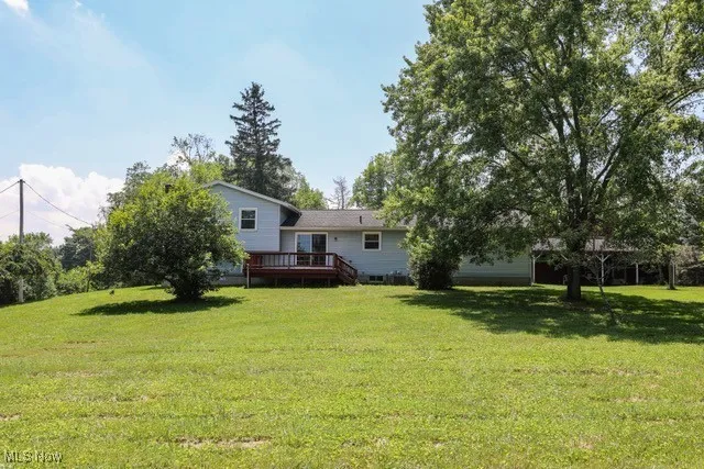 View of grassy yard with a deck