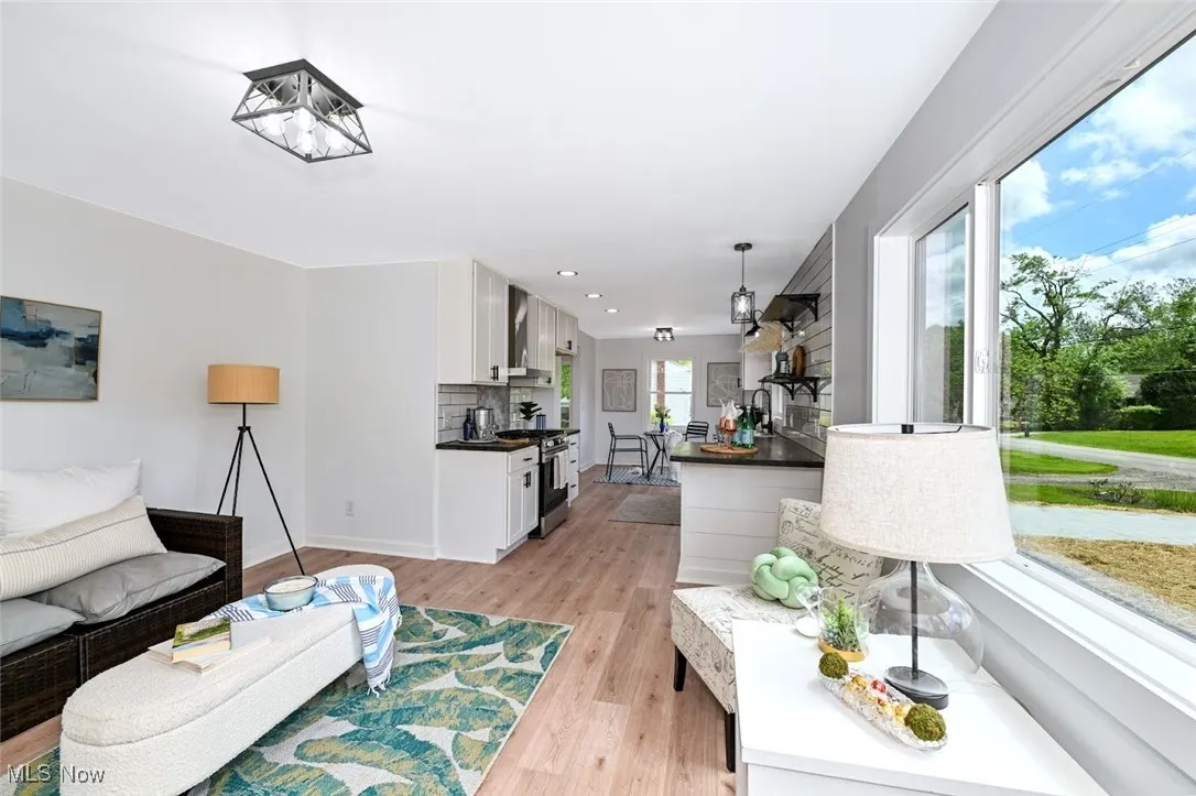 *LIVING RM W/RUSTIC FLOORING, NATURAL LIGHT FROM LARGE NEW PICTURE WINDOS ~ OPEN TO THE EAT IN KITCHEN FLOWS SEAMLESSY ~
