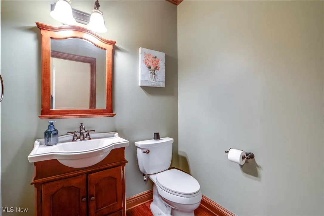 Half bath featuring vanity and wood finished floors