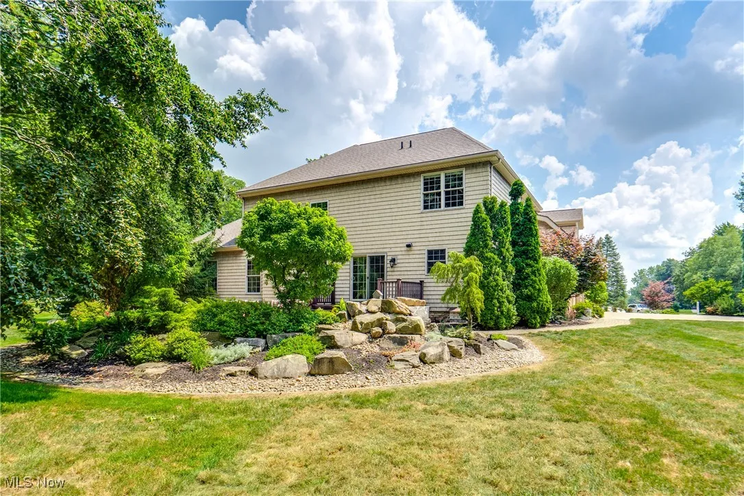 Rear view of property featuring a lawn and a shingled roof
