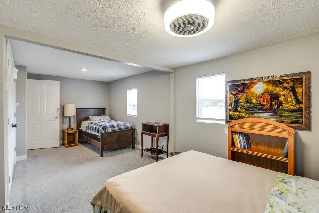 Bedroom featuring a textured ceiling, baseboards, and carpet floors