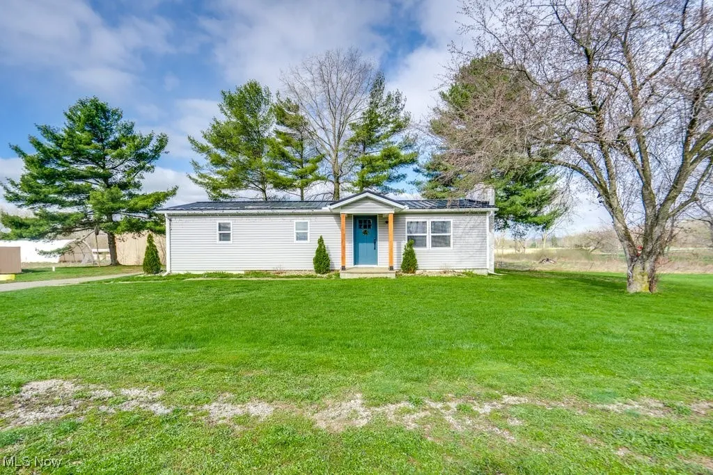 View of front of house featuring fence and a front lawn
