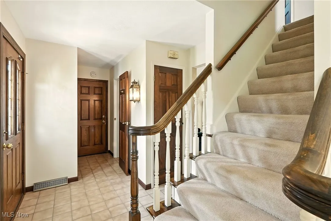 Entrance foyer featuring stairs and baseboards