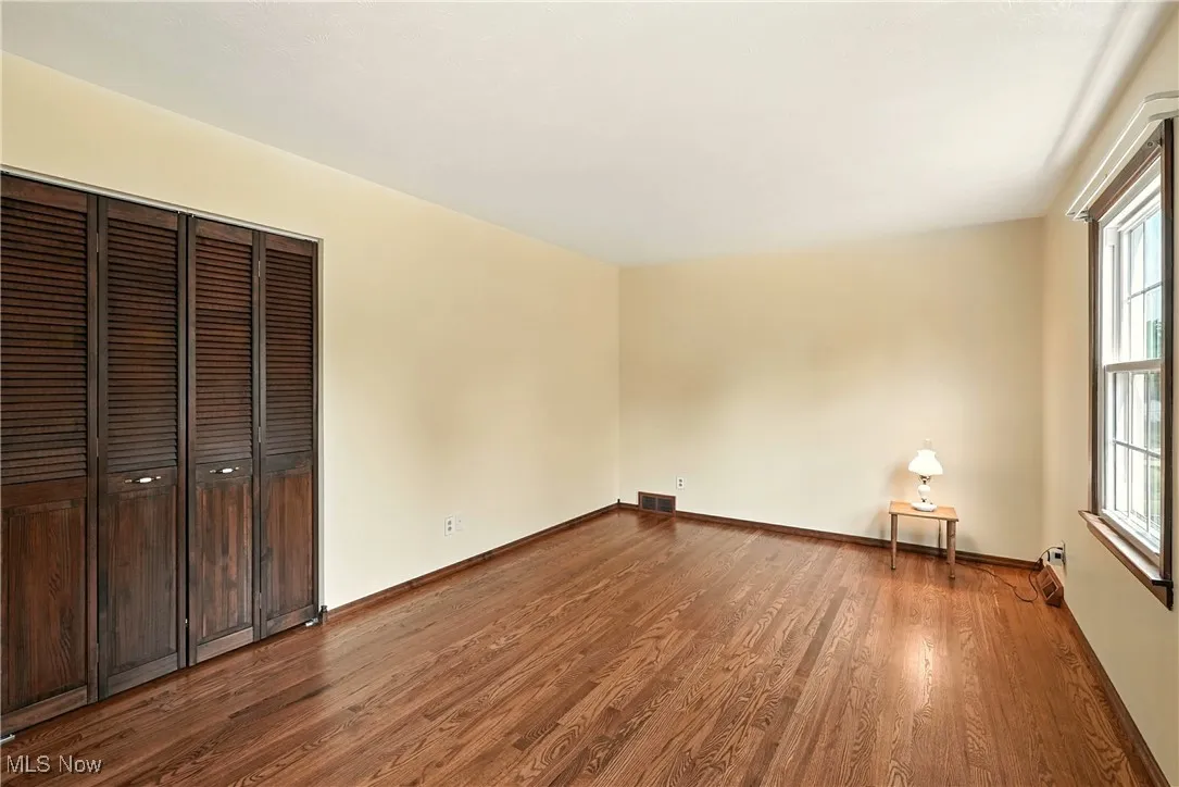 Unfurnished bedroom featuring dark wood-type flooring and a closet