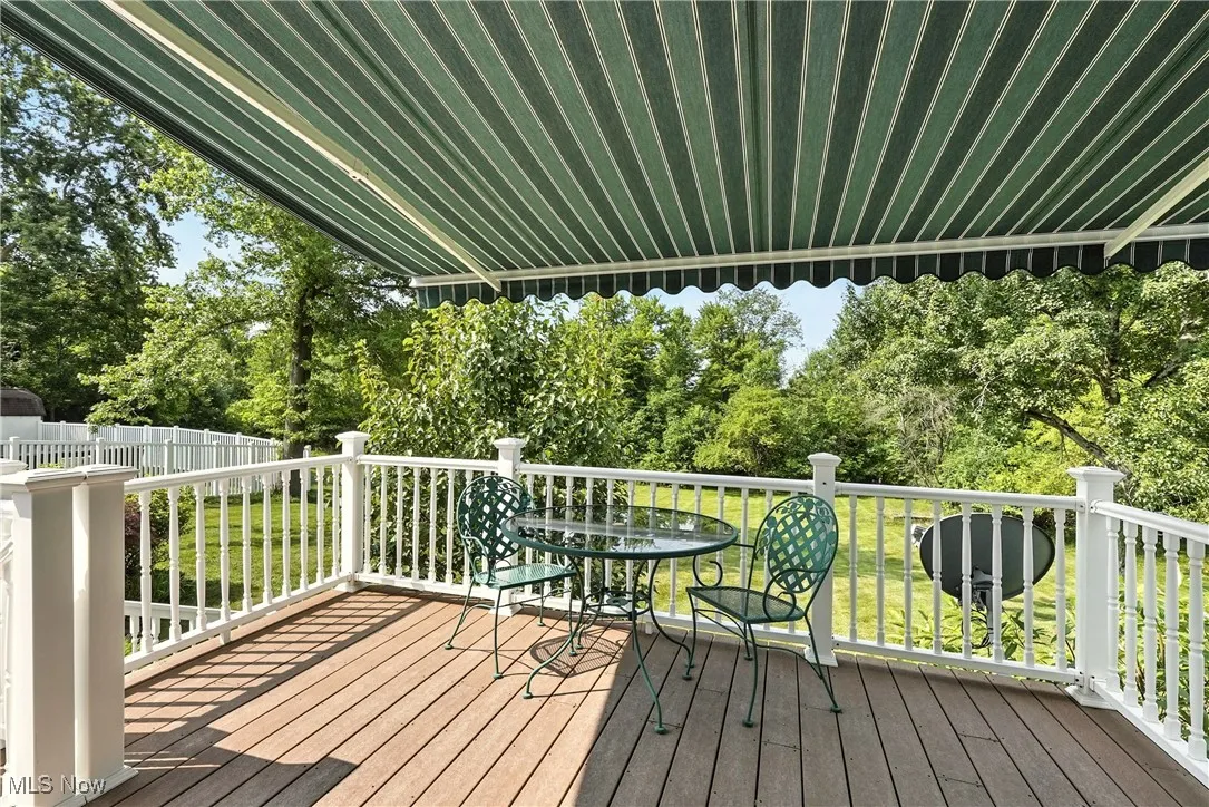 Wooden terrace featuring view of wooded area