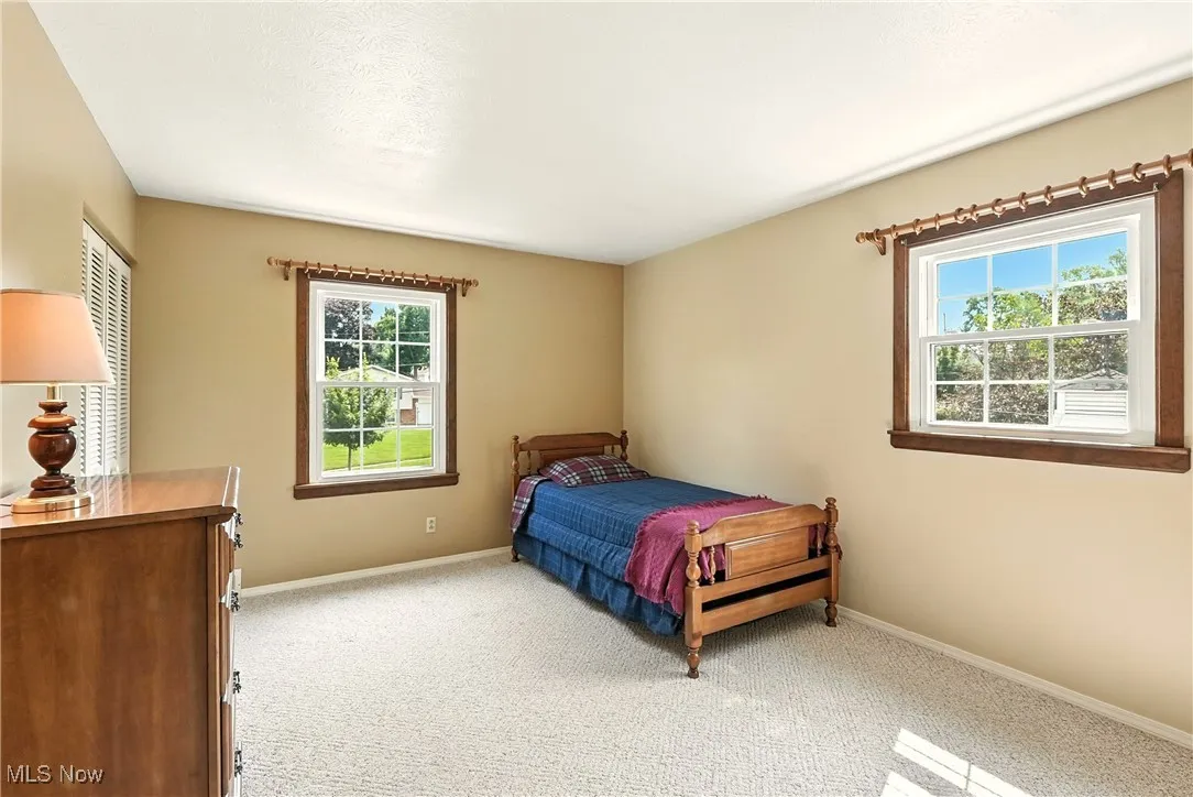 Bedroom with light colored carpet and baseboards