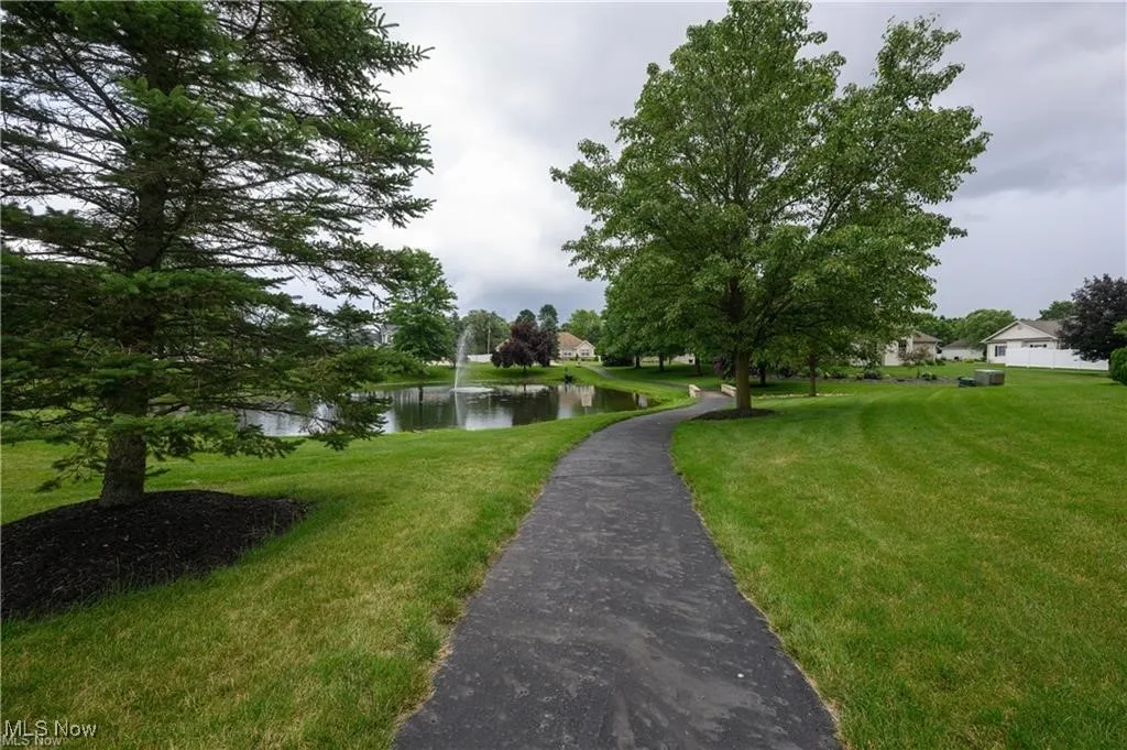 View of community featuring a water view and a yard