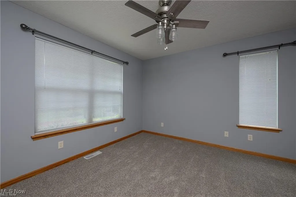 Spare room featuring a ceiling fan, carpet floors, and a textured ceiling