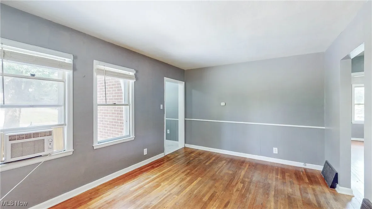 Unfurnished room with wood finished floors and cooling unit