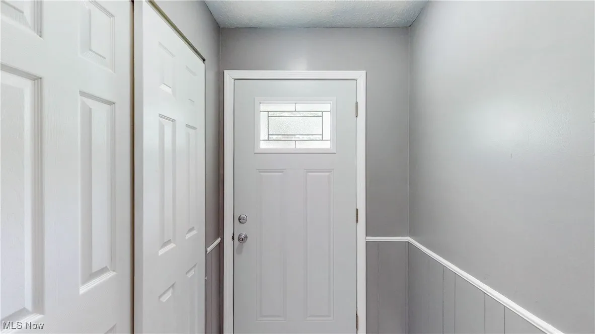 Entryway with wainscoting and a textured ceiling