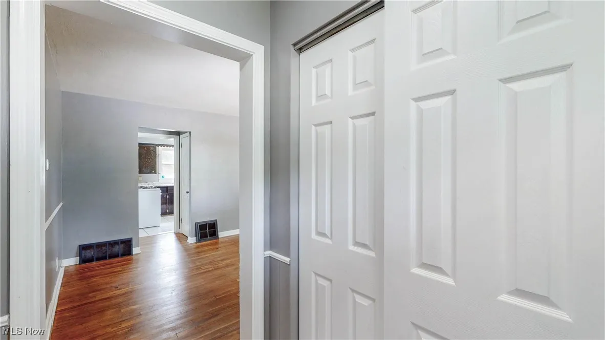 Corridor with dark wood-style flooring and baseboards