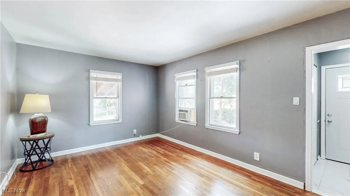 Unfurnished room featuring wood finished floors and cooling unit