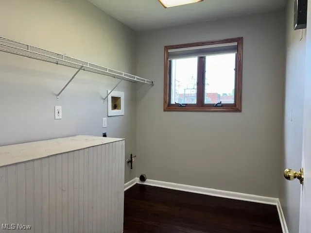 Laundry room with dark wood finished floors and hookup for a washing machine