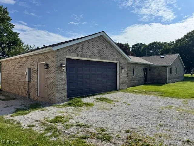 View of property exterior featuring a garage and brick siding