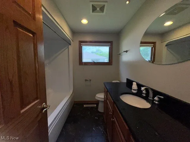 Bathroom with vanity, plenty of natural light, recessed lighting, and  shower combination