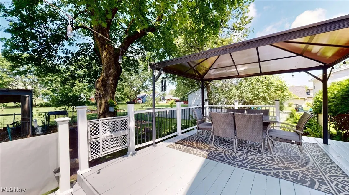 Wooden terrace with a gazebo and outdoor dining space