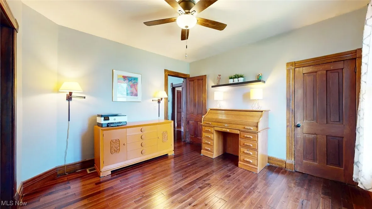 Home office/bedroom with ceiling fan and hardwood floors