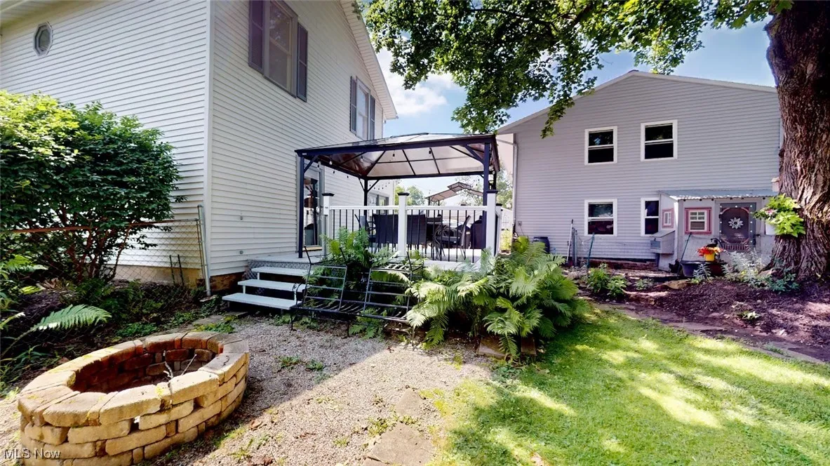 Rear view of house featuring a gazebo, an outdoor fire pit, a wooden deck