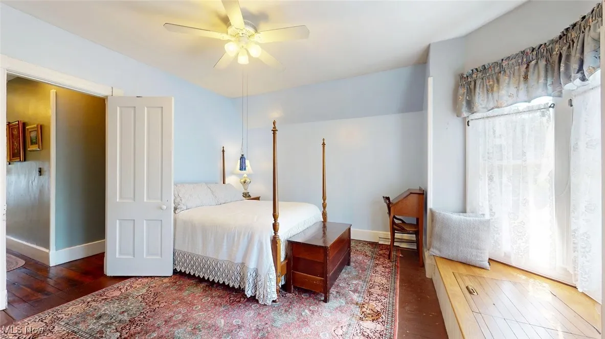 Bedroom featuring hardwood floors and storage