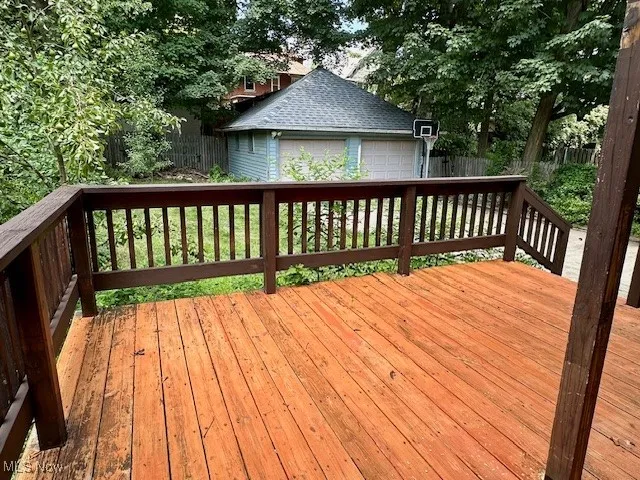 Wooden deck featuring a detached garage and an outdoor structure