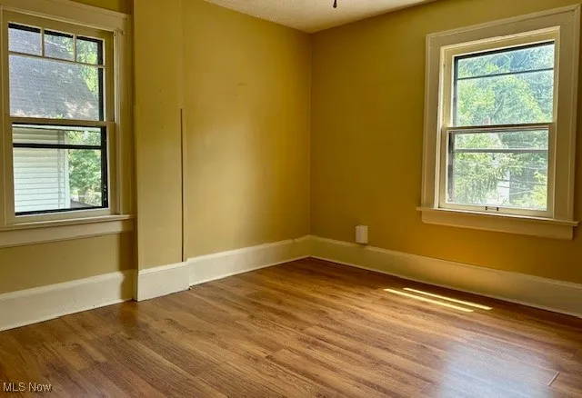 Spare room with wood finished floors and plenty of natural light