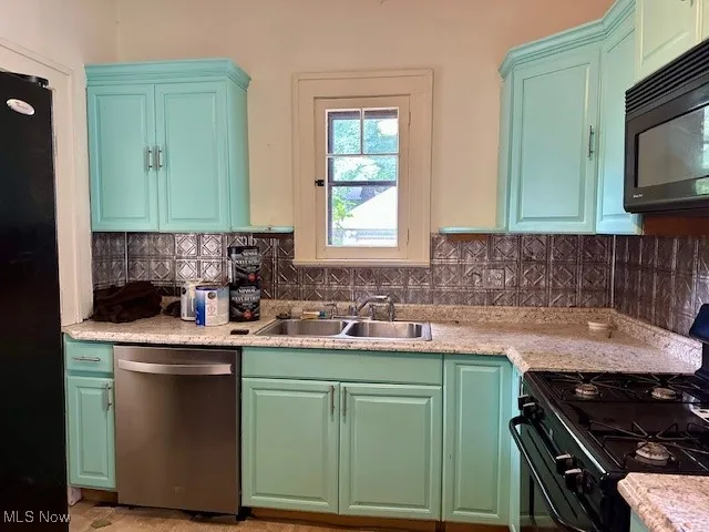 Kitchen featuring black appliances, tasteful backsplash, and light countertops