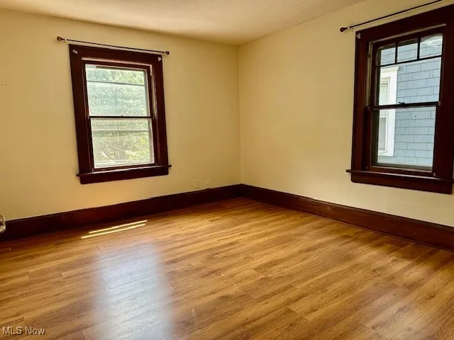 Spare room with baseboards and light wood-style flooring
