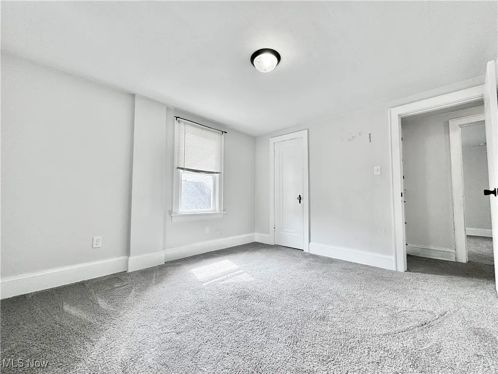 Unfurnished bedroom with carpet flooring and baseboards