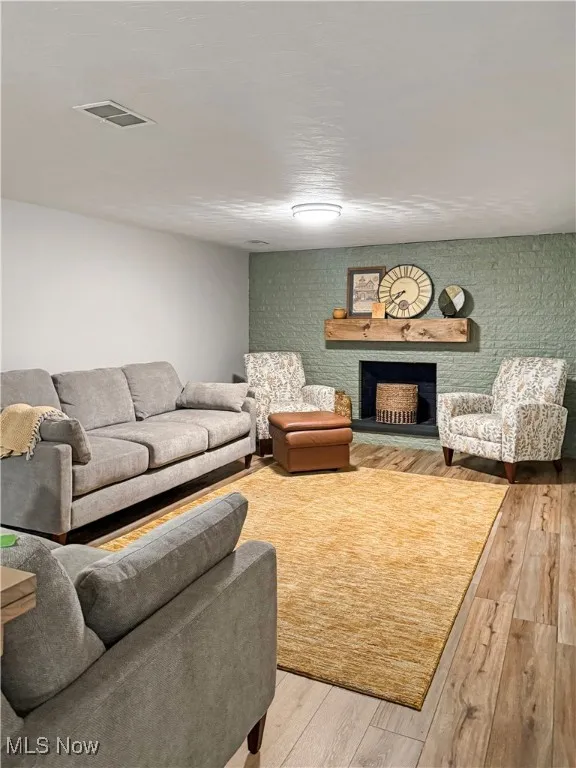Living area featuring hardwood / wood-style floors and a fireplace with raised hearth
