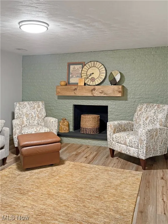 Sitting room featuring a fireplace and wood finished floors