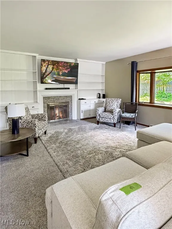 Living room with a fireplace and built in features